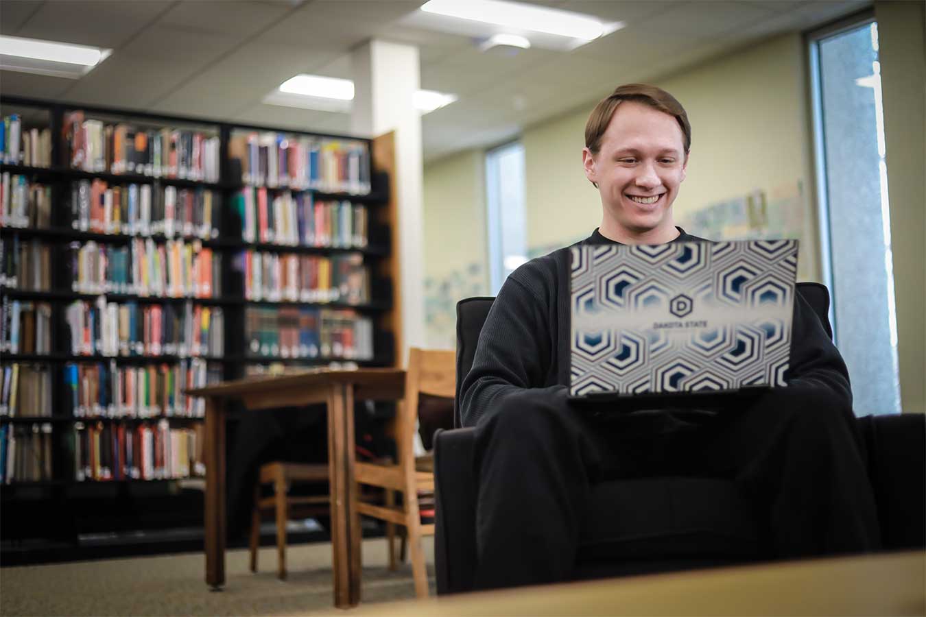 Justice Forster working at his computer in a library.